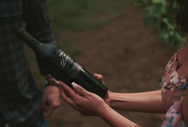 A woman holding a Smith Devereux wine bottle.