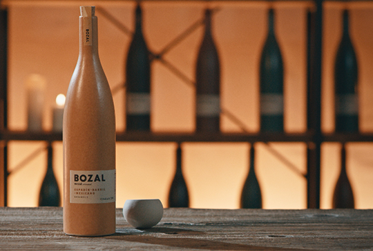 A bottle of wine labeled "BOZAL" placed on a table.