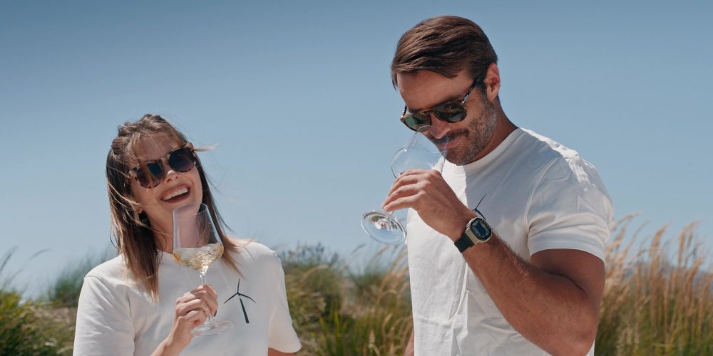 Full outdoor shot of a woman and a man, enjoying a glass of wine.