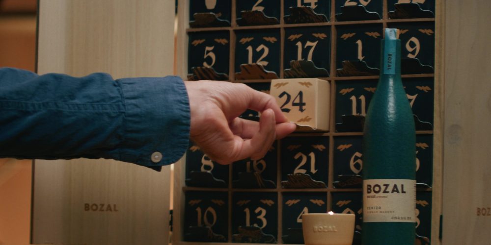 A hand pulls a gift box from an advent calendar.