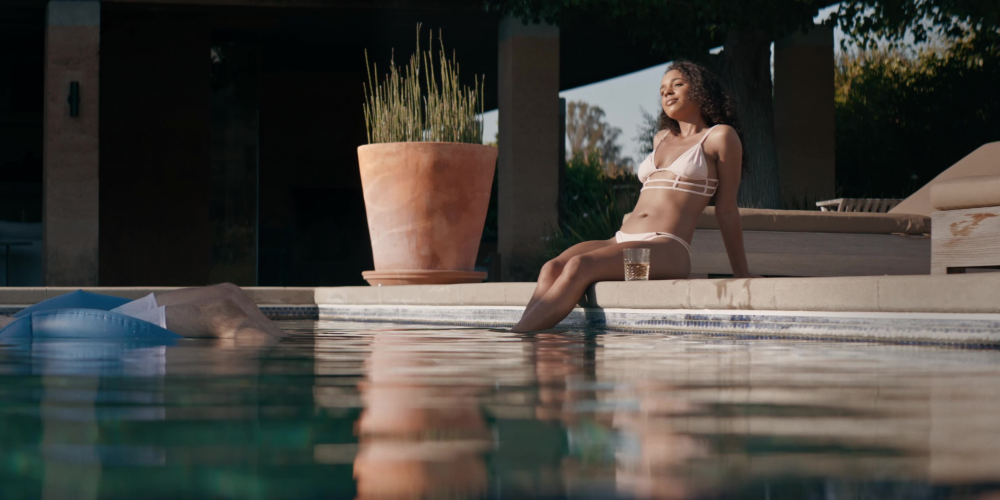 Woman relaxing by the pool with a glass of tequila.